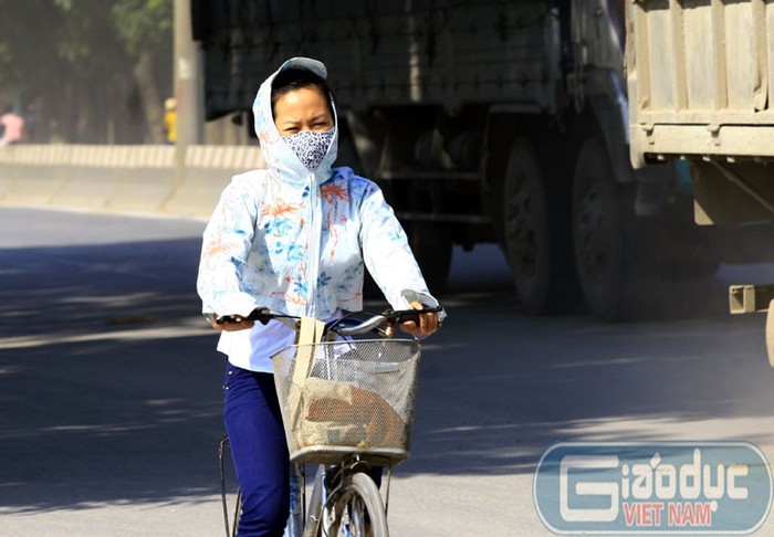 Đi trên đường phố Hà Nội, nhiều người phải ăn mặc kín để tránh nắng nóng